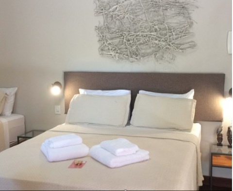 Suíte de casal com cama king size e iluminação quente